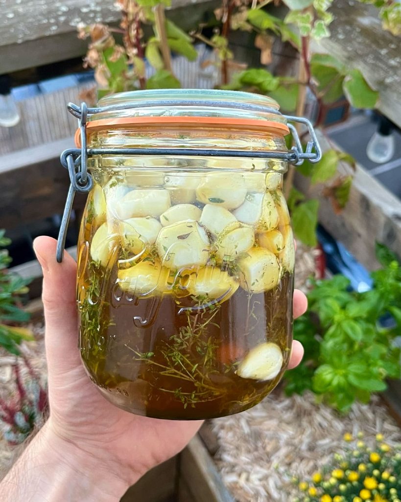 Bocal avec ail fermenté au miel et au thym